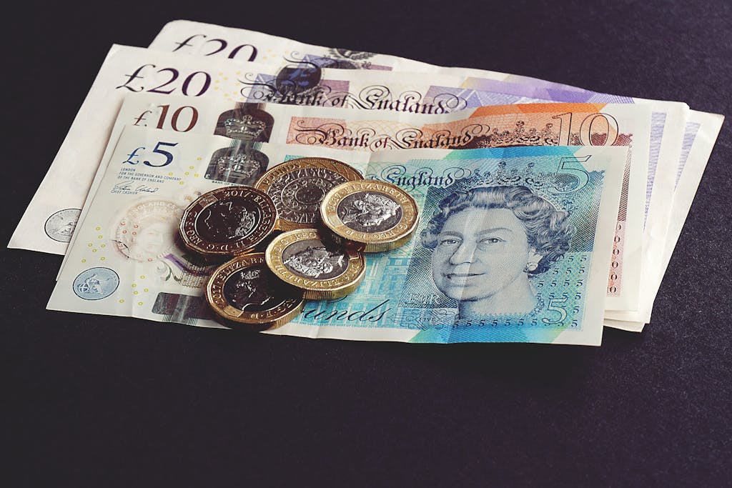 What We Plant in Our Kids’ Minds About Money Grows Wild – Water Wisely 🌧️🧠 2 High-quality image of British pound notes and coins on a dark surface, showcasing currency detail.